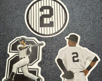 May include: Set of three baseball-themed stickers. One sticker features the number 2 inside a striped circle. The other two stickers depict a baseball player in a pinstripe uniform, one batting and the other in a fielding position.