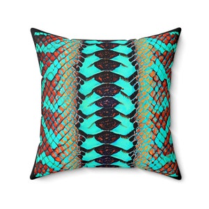 May include: A turquoise and orange pillow with a snake skin pattern.