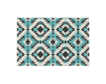 Pode incluir: Têxtil retangular com um padrão geométrico do sudoeste. O design apresenta formas repetidas de diamantes e ziguezagues em turquesa, preto e branco sujo. O padrão é simétrico e cobre toda a superfície do têxtil.