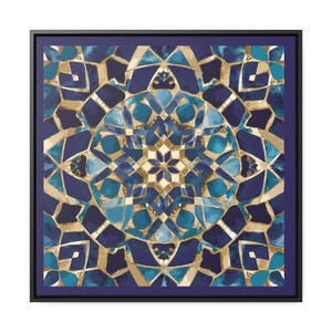May include: A framed square print with a geometric pattern in shades of blue and gold. The pattern is symmetrical and features a central star shape.