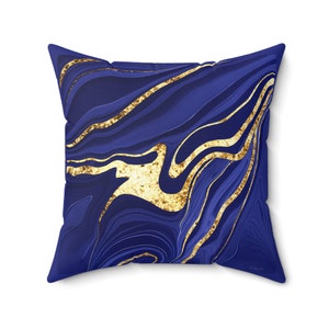 May include: A blue and gold throw pillow with a marbled pattern. The pillow has a square shape and is made of a soft, comfortable fabric.