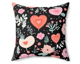 May include: A black pillow with a repeating pattern of pink and red hearts, flowers, and leaves.