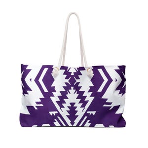 May include: A white tote bag with purple geometric patterns. The bag has white rope handles.