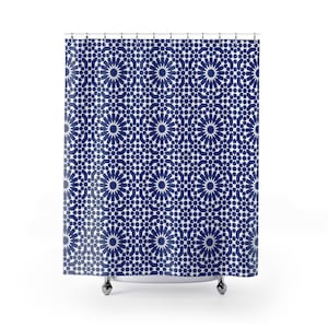 May include: A shower curtain with a repeating geometric pattern in navy blue and white. The design features a series of star-like shapes and floral motifs, creating a symmetrical and visually appealing aesthetic. The curtain hangs from a metal rod.