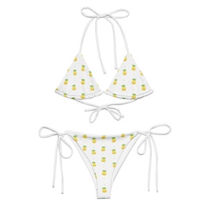 May include: White bikini with a pineapple print. The top is a triangle style with adjustable straps. The bottom is a cheeky style with adjustable ties on the sides.