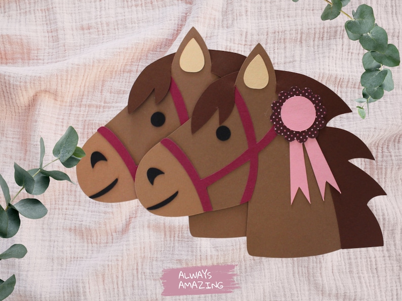 May include: Two brown paper horse heads with pink and red details. The horse on the right has a pink ribbon with a pink and white polka dot rosette. The text "ALWAYS AMAZING" is written in pink on a white background.