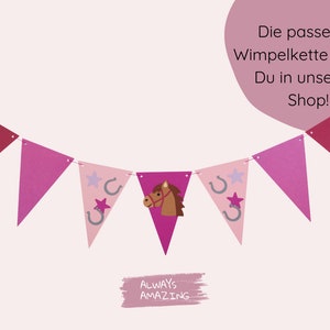 May include: Pink and red triangle shaped paper pennants with a horse, horseshoe, and star design. The pennants are strung together to form a banner. The text "ALWAYS AMAZING" is written on a pink background below the banner. The text "Die passende Wimpelkette findest Du in unserem Shop!" is written in white text on a pink circle in the upper right corner of the image.