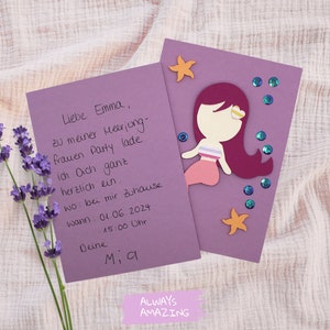 Op de afbeelding: Paarse uitnodigingskaart met een zeemeerminillustratie en glitteraccenten. De tekst op de kaart luidt "Liebe Emma, zu meiner Heerjong-frauen Party lade ich Dich ganz herzlich ein. wo: bei mir Zuhause Wann: 01.06.2024 15:00 Ohr Deine Mia"
