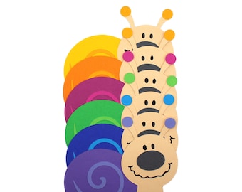May include: A colorful paper craft snail with a rainbow shell and a smiling face. The snail is made of paper and has a purple, blue, green, orange, and yellow shell. The snail has a black nose and eyes.