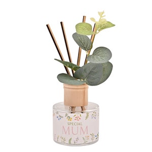 Puede incluir: Una botella de difusor de vidrio transparente con tapa de madera y palitos. La botella tiene un diseño floral y el texto "SPECIAL MUM" en la etiqueta.