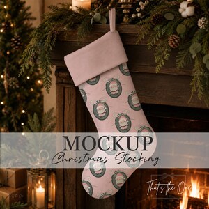 May include: A light pink Christmas stocking featuring a repeating pattern of Santa Claus figures inside dark green oval frames with bows. The stocking has a solid light pink cuff at the top and a fabric loop for hanging, presented as a product mockup.
