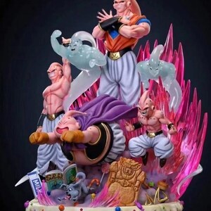 May include: A pink and white figurine of a character from the Dragon Ball Z anime series. The figurine is standing on a multi-colored cake with candy and other decorations. The character is surrounded by pink and white energy blasts.
