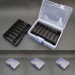 May include: A set of four clear plastic storage boxes with black dividers. The boxes have blue latches and are ideal for organising small items.