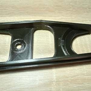 Puede incluir: Un gu&iacute;a de cadena de bicicleta impreso en 3D de pl&aacute;stico negro.