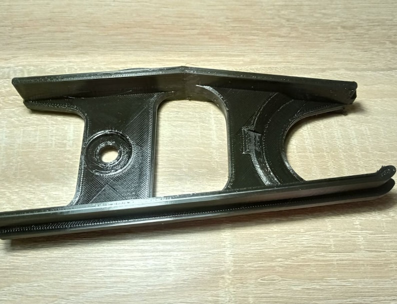 Puede incluir: Un gu&iacute;a de cadena de bicicleta impreso en 3D de pl&aacute;stico negro.