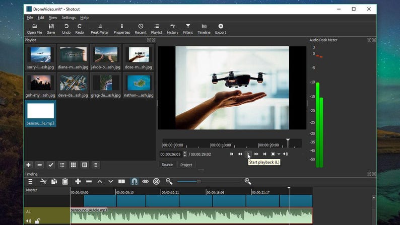 May include: A computer screen displaying the Shotcut video editing software interface. The workspace includes a playlist panel with multiple image thumbnails, a central preview window showing a drone, and a timeline with audio tracks.