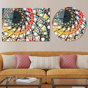 Op de afbeelding: Twee abstracte wandkunstwerken met een glas-in-loodontwerp in tinten blauw, rood, geel en bruin. Het ontwerp heeft een draaiend patroon dat een gevoel van diepte en beweging creëert.