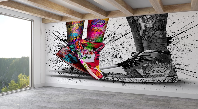 May include: A pair of sneakers with colorful graffiti designs, one black and white and the other with bright colors, against a white background with black paint splatters.