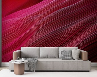 May include: A modern living room with a grey sofa and a small round side table. The wall behind the sofa is covered with wallpaper featuring a wavy pattern of red and pink lines.