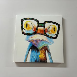 May include: A colourful painting of a frog wearing glasses. The frog is blue, yellow, orange, and green. The glasses are black with a rainbow pattern.
