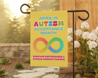 May include: A yellow garden flag with the text "APRIL IS AUTISM ACCEPTANCE MONTH" in colorful letters. An infinity symbol in rainbow colors is below the text. The text "EMBRACE DIFFERENCES & SPREAD UNDERSTANDING" is at the bottom of the flag.