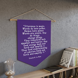 May include: Purple banner with a white quote by Ursula K. Le Guin about the power of words. The quote reads: "Utterance is magic. Words do have power. Names have power. Words are events, they do things, change things. They transform both speaker and hearer; they feed energy back and forth and amplify it. They feed understanding or emotion back and forth and amplify it."