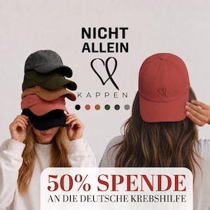 May include: A stack of five baseball caps in charcoal, olive, tan, terracotta, and black, alongside a single terracotta baseball cap featuring a small black heart outline. The text reads NICHT ALLEIN KAPPEN and 50% SPENDE AN DIE DEUTSCHE KREBSHILFE.