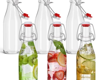 Può includere: Sei bottiglie in vetro trasparente con chiusura a leva e tappi rossi e bianchi. Tre bottiglie sono vuote, mentre le altre tre sono riempite con ghiaccio e infusi di frutta: una con kiwi e limone, una con fragola e limone, e una con lime.
