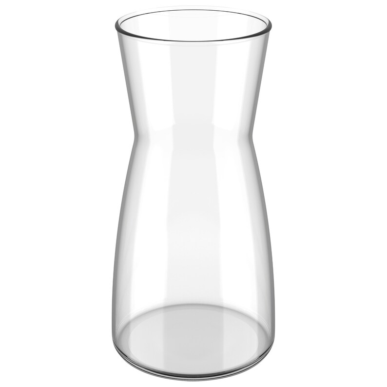May include: A clear glass pitcher with a wide base and a narrow neck. The pitcher is empty and has a smooth, polished surface.