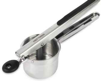 May include: A stainless steel potato ricer featuring a cylindrical hopper and a long lever handle with a black grip. The word HEFTMAN is printed on the metal arm. A small black circular knob is attached to the side of the hopper for stability.