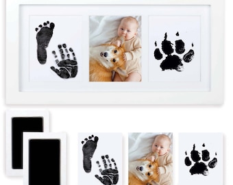May include: White picture frame with three openings. The center opening shows a photo of a baby and a dog. The left opening shows a baby's footprint and handprint. The right opening shows a dog's paw print. Two black ink pads are included.