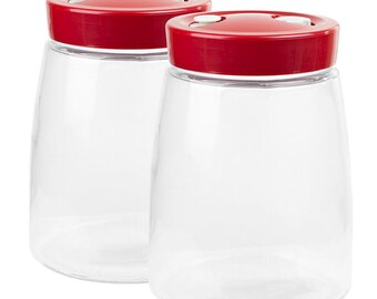 Può includere: Due barattoli in vetro trasparente con corpo affusolato e ampia apertura. Ogni barattolo è dotato di un coperchio in plastica rossa lucida con due piccole valvole o pulsanti circolari bianchi posizionati sulla parte superiore.