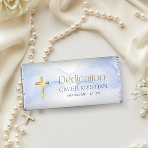 Puede incluir: Un diseño de acuarela azul y blanco con una cruz dorada y el texto "Dedication Caleb Kristian Melbourne 11.11.XX".