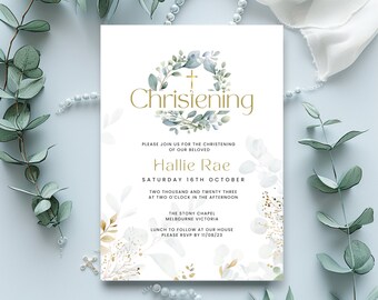 May include: A light blue and white christening invitation with gold lettering. The invitation features a watercolor wreath with eucalyptus leaves and a gold cross. The text reads "Chrisiening" and "Hallie Rae". The date and time of the christening are listed, along with the location and RSVP information.