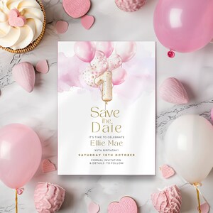May include: A pink and gold birthday invitation with the text "Save the Date" and "Ellie Mae". The invitation features pink balloons and a number one balloon. The invitation is surrounded by pink decorations and a cupcake.