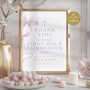 Puede incluir: Un cartel con marco dorado con una ilustración de acuarela de un lazo rosa y una cruz. El cartel dice "¡Gracias! Por hacer de mi Primera Comunión un momento tan dulce. Por favor, toma un dulce. Ella Marie 20/07/2023".