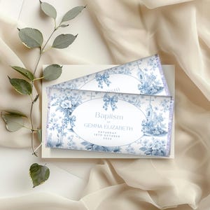 May include: Blue and white baptism favor chocolate bar wrappers with a floral design and a church illustration. The text reads "Baptism of Gemma Elizabeth Saturday 15th October 2024".