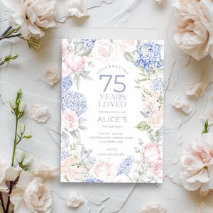 May include: An elegant invitation for a 75th birthday, featuring a floral design with pink roses and blue hydrangeas. The text reads "Celebrating 75 Years Loved" and includes event details, perfect for a special occasion.