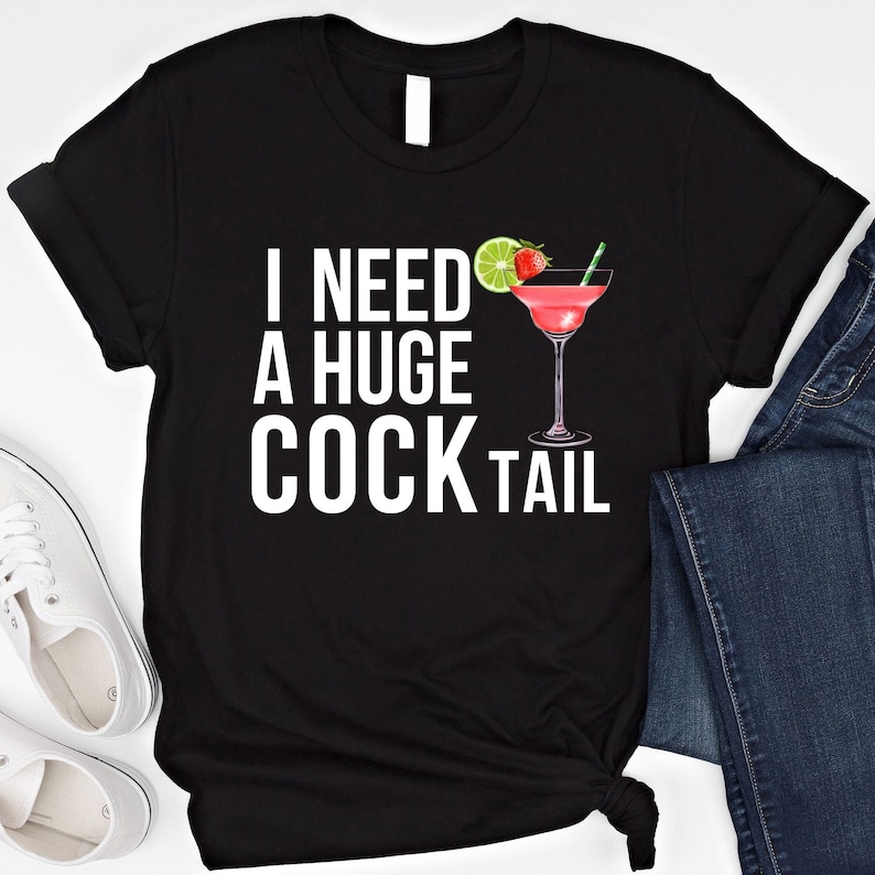 May include: Black t-shirt with white text that reads "I need a huge cocktail" and a pink cocktail with a lime and strawberry garnish.
