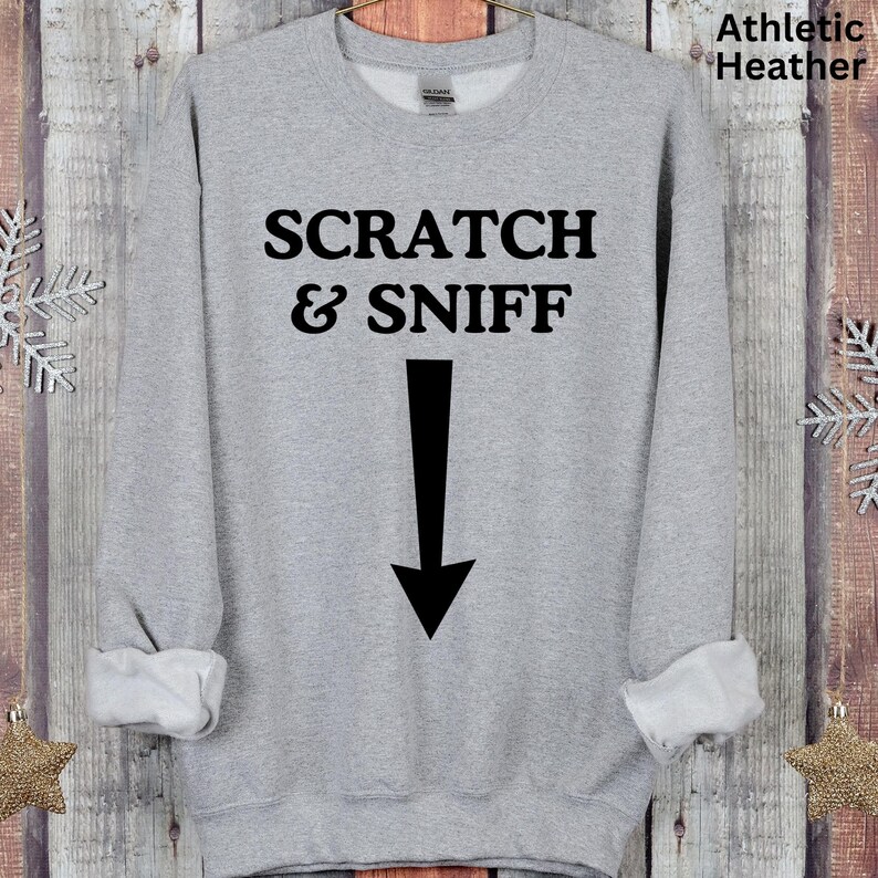May include: Grey sweatshirt with the text "SCRATCH & SNIFF" and a black arrow pointing down.