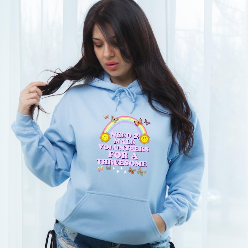May include: Light blue hoodie with a rainbow, butterflies, and the text "Need 2 Male Volunteers For A Threesome".