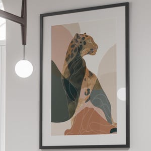 May include: A framed art print featuring a stylized leopard illustration in shades of brown, green, and peach. The artwork is displayed on a white wall above a black dining table with matching chairs.