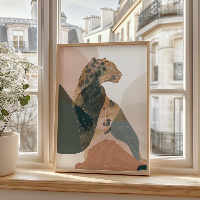 May include: A framed art print featuring a stylized leopard illustration. The artwork uses a palette of muted earth tones, including brown, beige, and teal, with a minimalist design. The leopard is depicted in a seated pose, with a simple outline.