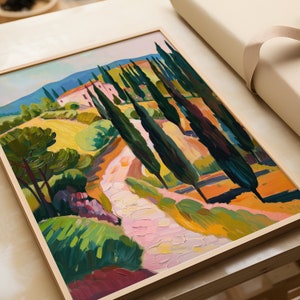 Puede incluir: Una pintura enmarcada de un paisaje con una casa rosa, un camino de tierra sinuoso y &aacute;rboles altos y verdes. La pintura est&aacute; realizada en un estilo estilizado, casi abstracto, con trazos de color audaces.
