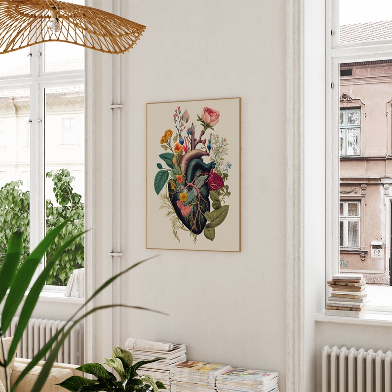 May include: A vintage botanical print featuring a human heart with flowers growing from it. The heart is surrounded by a variety of flowers in shades of pink, red, and white. The print is framed in a simple, cream-colored frame.
