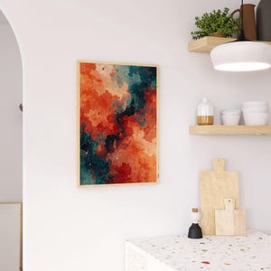 May include: Abstract art print in a wooden frame. The artwork features a watercolor design with shades of red, orange, and teal, creating a dynamic and colorful composition. The print is displayed on a white wall.