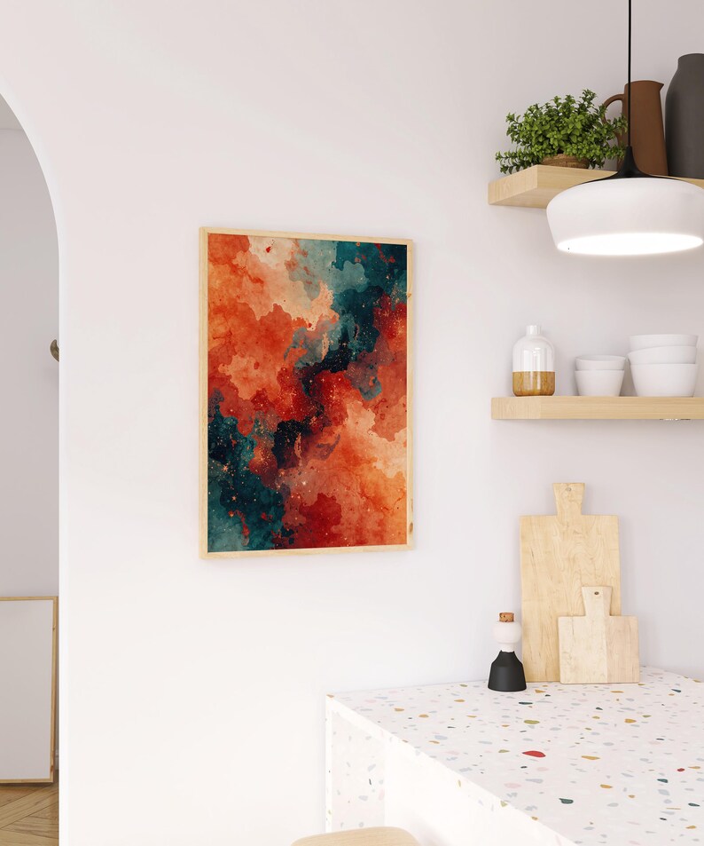 May include: Abstract art print in a wooden frame. The artwork features a watercolor design with shades of red, orange, and teal, creating a dynamic and colorful composition. The print is displayed on a white wall.
