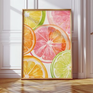 May include: A framed watercolor print featuring vibrant citrus fruit slices. The artwork showcases oranges, grapefruits, lemons, and limes in shades of orange, pink, yellow, and green. The wooden frame complements the colorful fruit art.