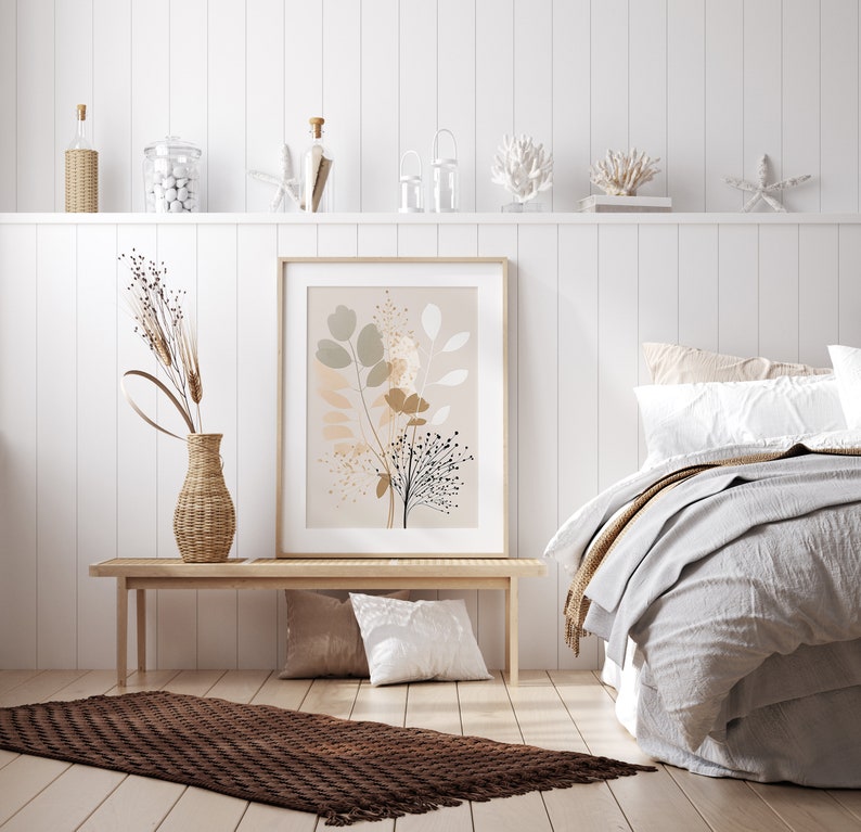 May include: A white bedroom with a wooden bench and a brown rug. A framed print with a floral design hangs on the wall above the bench. A bed with white and beige bedding is in the background.