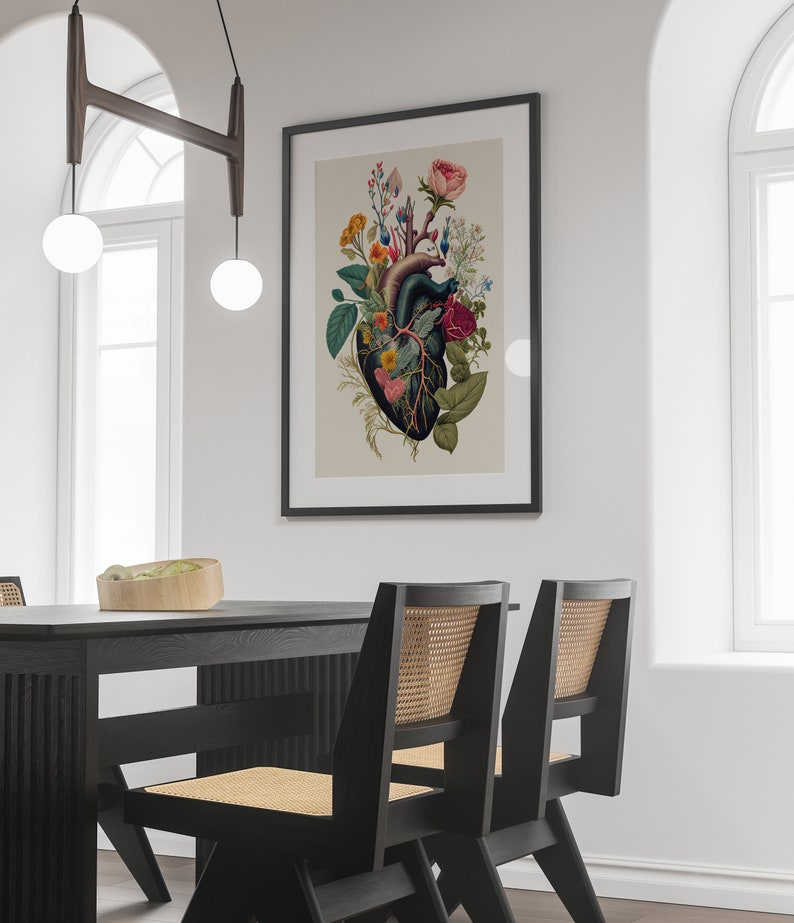 May include: A black framed print of a human heart with flowers growing from it. The heart is a dark red color and the flowers are a variety of colors, including pink, red, yellow, and white.